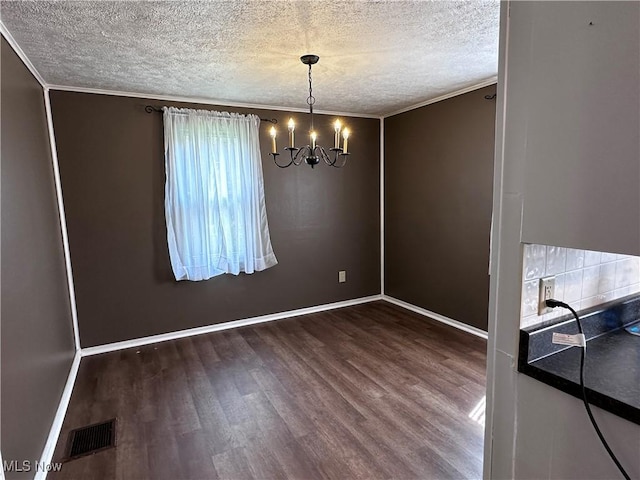 1029 Fowler Dr, Caldwell, OH 43724 - unfurnished dining area featuring a textured ceiling, wood finished floors, a chandelier, baseboards, and ornamental molding