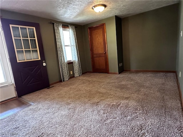 1029 Fowler Dr, Caldwell, OH 43724 - entrance foyer with light carpet, a textured ceiling, and baseboards