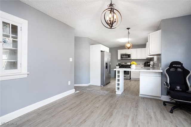 1168 Onondago Ave, Akron, OH 44305 - kitchen featuring appliances with stainless steel finishes, light wood-type flooring, a chandelier, light countertops, and white cabinetry