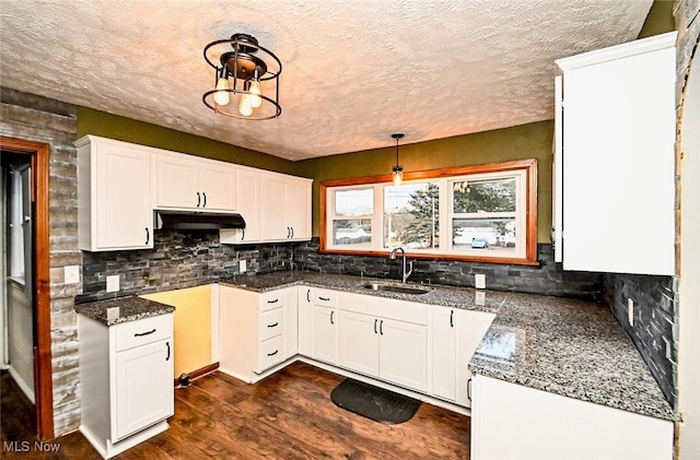 3811 Amherst Ave NW, Massillon, OH 44646 - kitchen with dark wood finished floors, decorative backsplash, white cabinetry, under cabinet range hood, and a textured ceiling