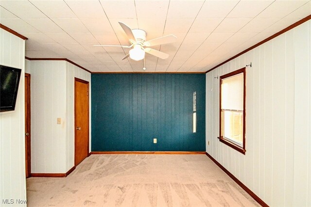3811 Amherst Ave NW, Massillon, OH 44646 - unfurnished room with ornamental molding, light carpet, a ceiling fan, and wood walls