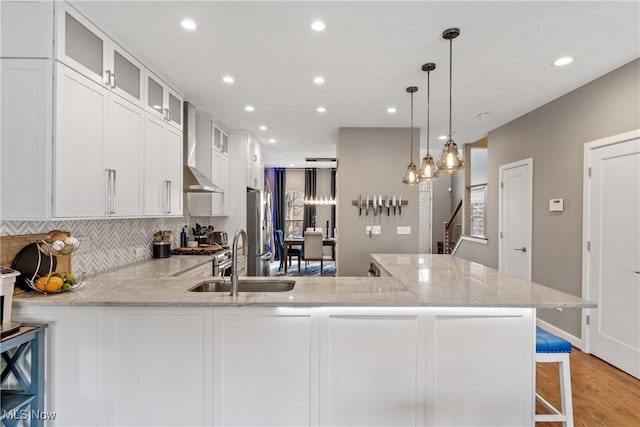 2164 W 6th St, Cleveland, OH 44113 - kitchen with light wood finished floors, light stone counters, recessed lighting, white cabinetry, and backsplash