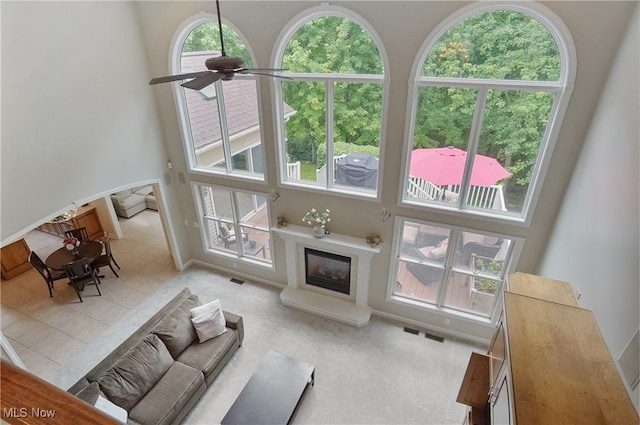 2634 Deer Ridge Run, Cuyahoga Falls, OH 44223 - living area featuring a high ceiling, a glass covered fireplace, and a ceiling fan