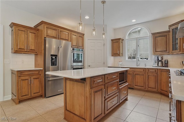2634 Deer Ridge Run, Cuyahoga Falls, OH 44223 - kitchen featuring stainless steel appliances, brown cabinetry, a center island, tasteful backsplash, and light tile patterned floors