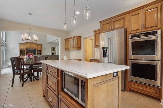2634 Deer Ridge Run, Cuyahoga Falls, OH 44223 - kitchen featuring stainless steel appliances, light tile patterned floors, light countertops, brown cabinets, and a center island