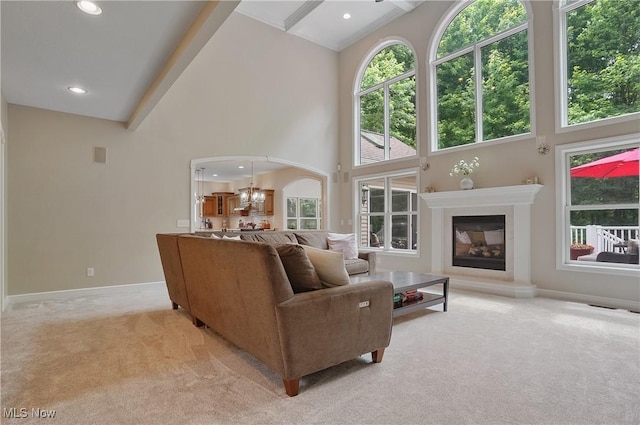 2634 Deer Ridge Run, Cuyahoga Falls, OH 44223 - living room with light colored carpet, high vaulted ceiling, a chandelier, a glass covered fireplace, and arched walkways