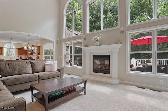 2634 Deer Ridge Run, Cuyahoga Falls, OH 44223 - living area featuring a high ceiling, a high end fireplace, a chandelier, and light carpet