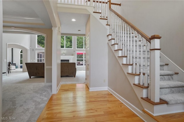 2634 Deer Ridge Run, Cuyahoga Falls, OH 44223 - stairs with arched walkways, wood finished floors, a fireplace, recessed lighting, and a towering ceiling