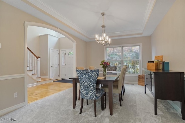 2634 Deer Ridge Run, Cuyahoga Falls, OH 44223 - dining area featuring light carpet, a chandelier, arched walkways, a raised ceiling, and ornamental molding