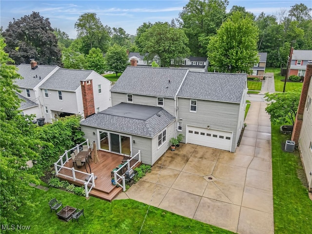 1120 Croyden Rd, Lyndhurst, OH 44124 - rear view of property featuring a wooden deck, roof with shingles, an attached garage, a lawn, and a residential view