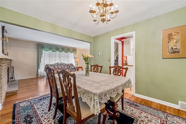 1120 Croyden Rd, Lyndhurst, OH 44124 - dining area featuring a chandelier, wood finished floors, and a fireplace