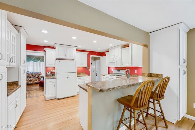 1120 Croyden Rd, Lyndhurst, OH 44124 - kitchen featuring white appliances, light wood-type flooring, a peninsula, a breakfast bar, and recessed lighting