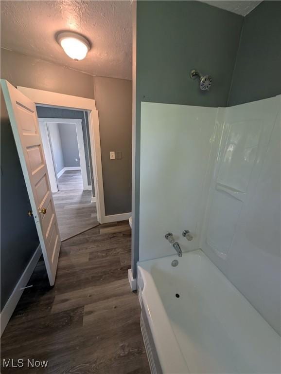 908 W 8th St, Lorain, OH 44052 - full bath featuring wood finished floors, a textured ceiling, and tub / shower combination