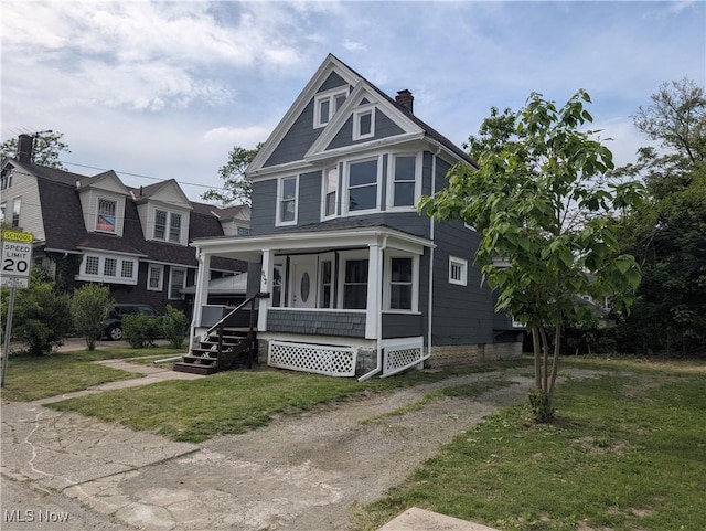 908 W 8th St, Lorain, OH 44052 - traditional style home with a porch, a chimney, a front yard, and dirt driveway
