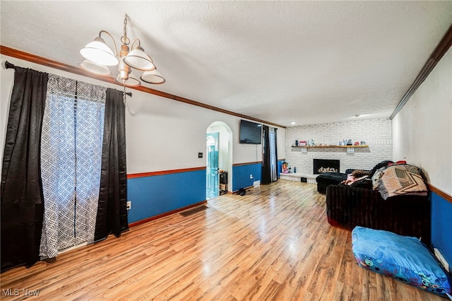 3310 Wilson Ave, Ashtabula, OH 44004 - living room with wood finished floors, ornamental molding, arched walkways, a brick fireplace, and wainscoting