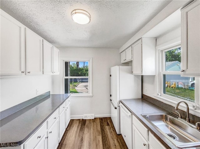 24451 Devoe Ave, Euclid, OH 44123 - kitchen with a textured ceiling, dark wood finished floors, white cabinets, white appliances, and dark countertops