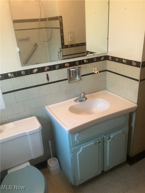 7718 Bertha Ave, Parma, OH 44129 - bathroom with tile walls, vanity, and a wainscoted wall