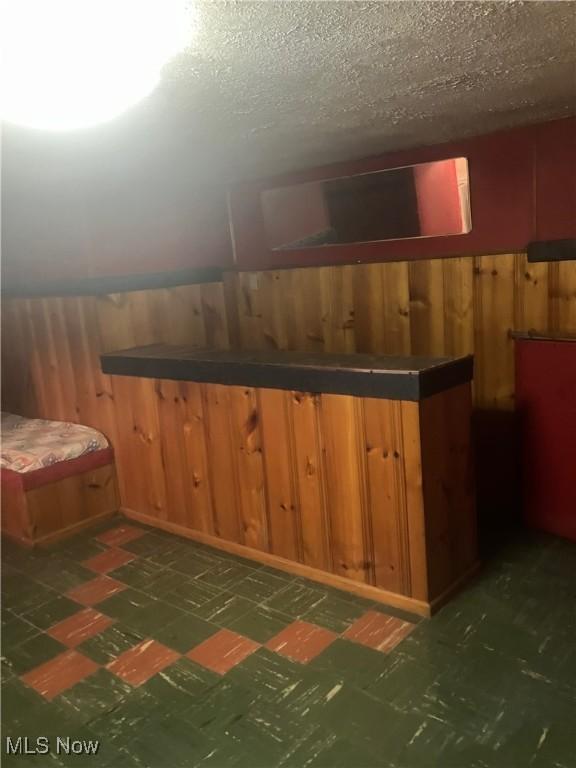 7718 Bertha Ave, Parma, OH 44129 - finished basement featuring tile patterned floors, a dry bar, wooden walls, and a wainscoted wall