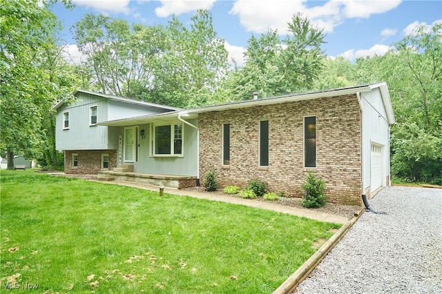 53 Joel Dr, Mogadore, OH 44260 - split level home with a front lawn, gravel driveway, brick siding, and an attached garage