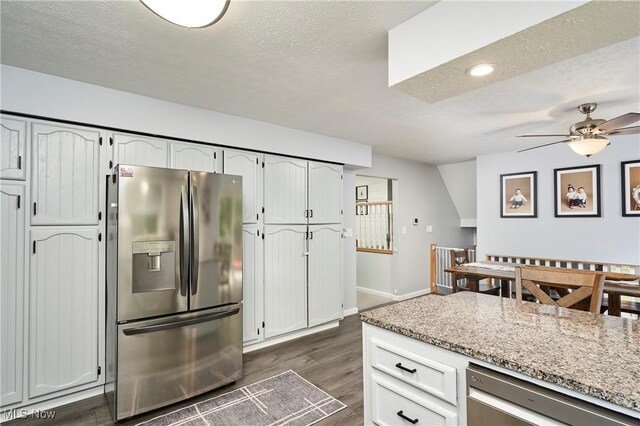 53 Joel Dr, Mogadore, OH 44260 - kitchen with appliances with stainless steel finishes, a ceiling fan, dark wood-style floors, a textured ceiling, and light stone counters