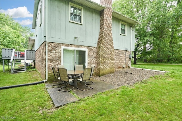 53 Joel Dr, Mogadore, OH 44260 - rear view of property featuring a wooden deck, a yard, a chimney, and brick siding