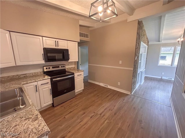 837 Pinecrest Rd, Girard, OH 44420 - kitchen featuring black microwave, stainless steel range with electric cooktop, a chandelier, white cabinets, and light countertops