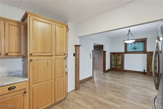 722 Clark St, Cambridge, OH 43725 - kitchen with freestanding refrigerator, light wood-style floors, hanging light fixtures, and light stone counters