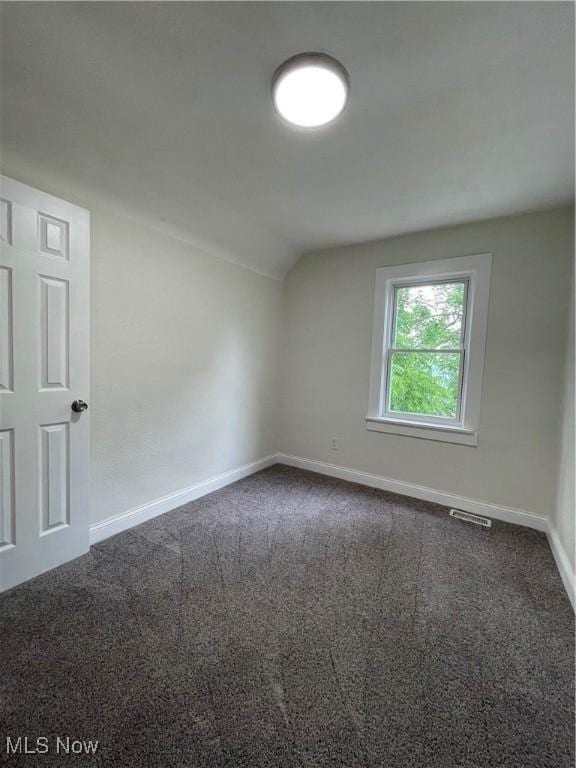 124 W 29th St, Lorain, OH 44055 - spare room featuring vaulted ceiling and dark carpet