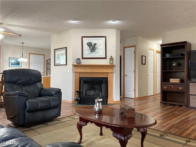 454 Lincoln Ave NW, Carrollton, OH 44615 - living area featuring wood finished floors, ceiling fan, a textured ceiling, and a fireplace