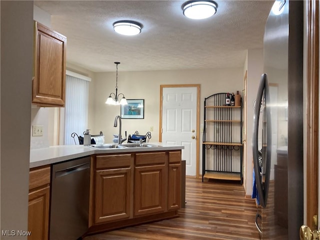 454 Lincoln Ave NW, Carrollton, OH 44615 - kitchen featuring appliances with stainless steel finishes, dark wood-style flooring, a peninsula, a textured ceiling, and brown cabinetry