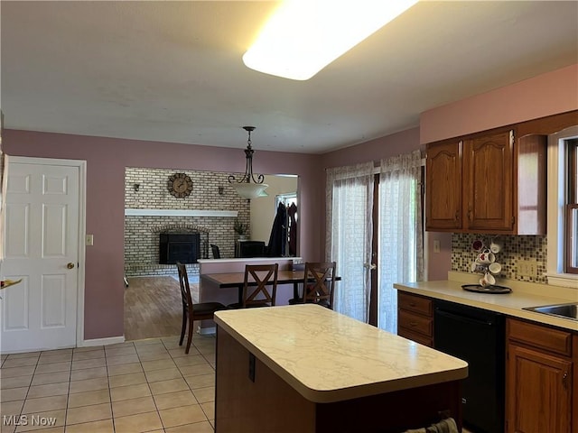 199 Kanawha Rd, Weirton, WV 26062 - kitchen with dishwasher, light countertops, a brick fireplace, a center island, and brown cabinets