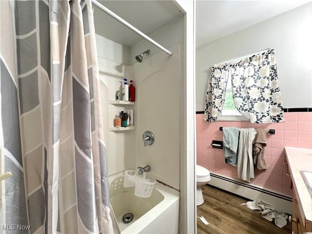1415 E Main St, Kent, OH 44240 - bathroom with a baseboard radiator, tile walls, wood finished floors, vanity, and shower / bathtub combination with curtain