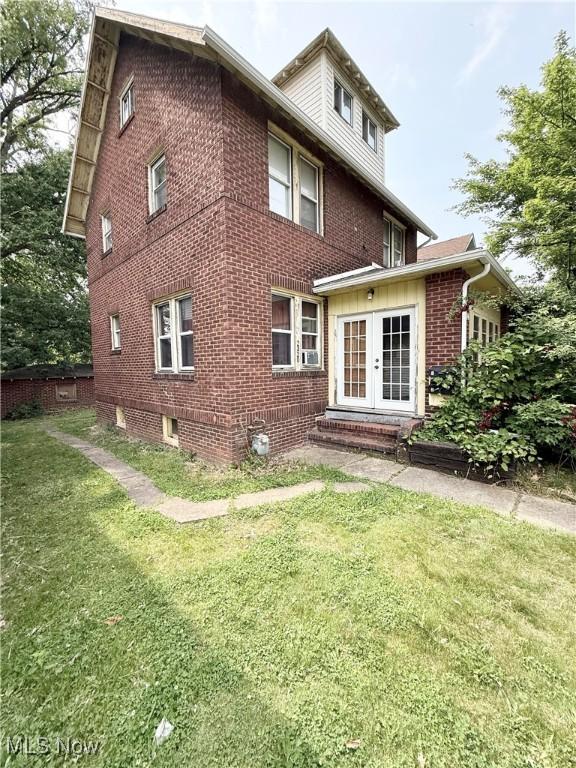 2320 22nd St SW, Akron, OH 44314 - rear view of property with a lawn, brick siding, and french doors
