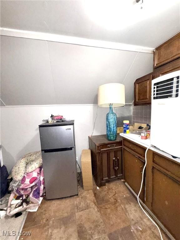 2320 22nd St SW, Akron, OH 44314 - kitchen with freestanding refrigerator, lofted ceiling, light countertops, and tasteful backsplash