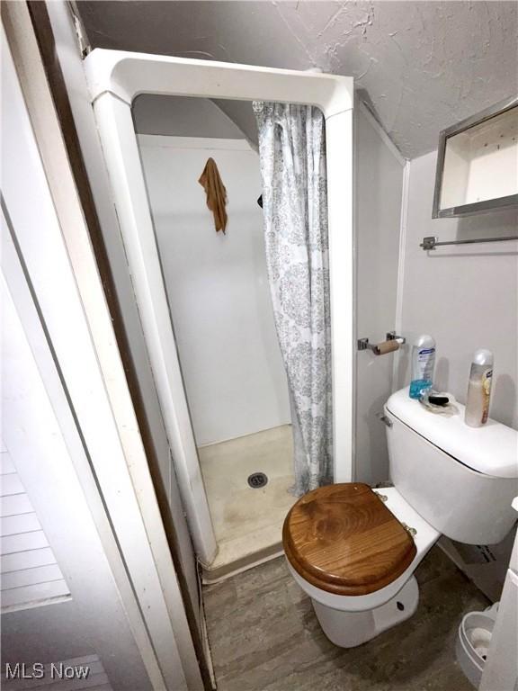 2320 22nd St SW, Akron, OH 44314 - full bathroom with a shower stall and wood finished floors