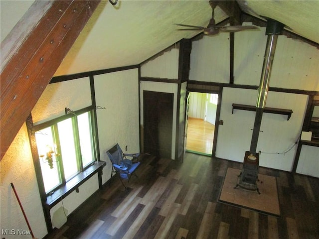 220 Daniels Ave, Conneaut, OH 44030 - unfurnished living room featuring ceiling fan, wood finished floors, a wood stove, and high vaulted ceiling