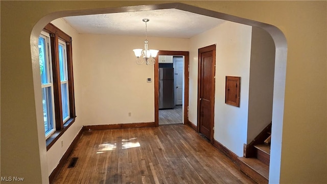 1014 20th St, Parkersburg, WV 26101 - unfurnished dining area with wood finished floors, arched walkways, healthy amount of natural light, and a chandelier