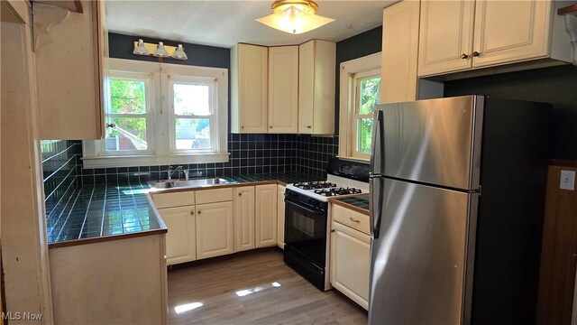 1014 20th St, Parkersburg, WV 26101 - kitchen with black gas range, freestanding refrigerator, tasteful backsplash, and tile counters