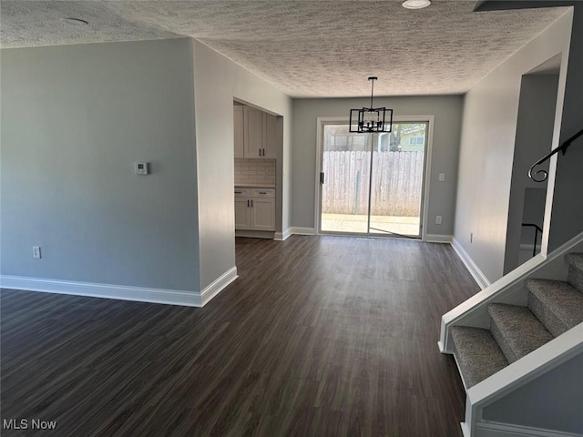 275 Butternut Ln, Berea, OH 44017 - unfurnished dining area with stairs, a chandelier, dark wood-style floors, and a textured ceiling