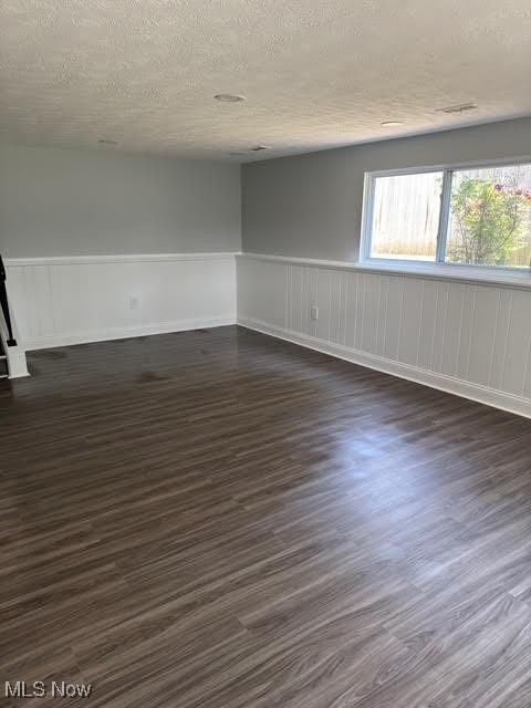 275 Butternut Ln, Berea, OH 44017 - empty room featuring wainscoting, dark wood-style flooring, and a textured ceiling
