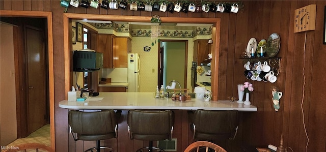 593 Furnace Rd, Conneaut, OH 44030 - bar area with freestanding refrigerator, wooden walls, and tile patterned floors