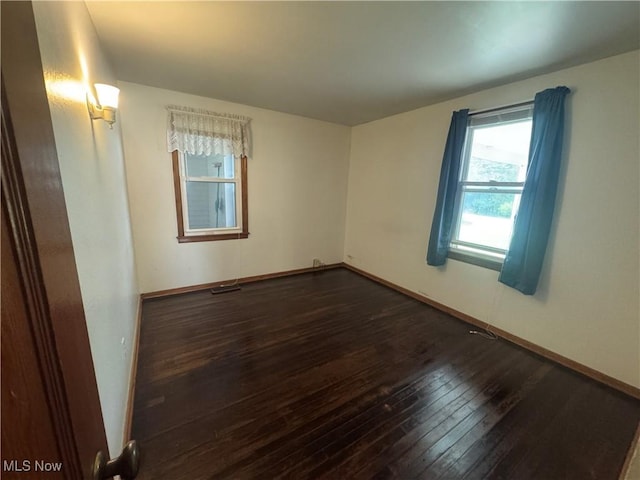 1015 Belford St, Caldwell, OH 43724 - empty room with dark wood finished floors and healthy amount of natural light