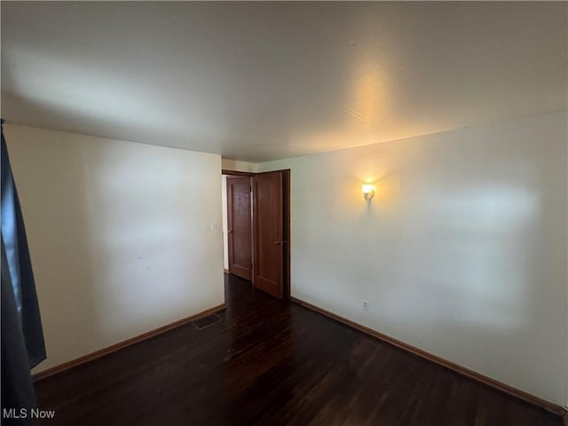 1015 Belford St, Caldwell, OH 43724 - spare room featuring dark wood-type flooring and baseboards