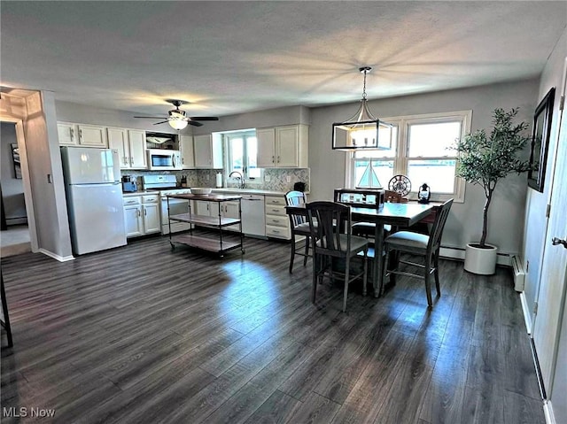 7374 Eisenhower Dr Unit 5, Boardman, OH 44512 - dining area featuring healthy amount of natural light, dark wood-type flooring, a ceiling fan, and a baseboard heating unit