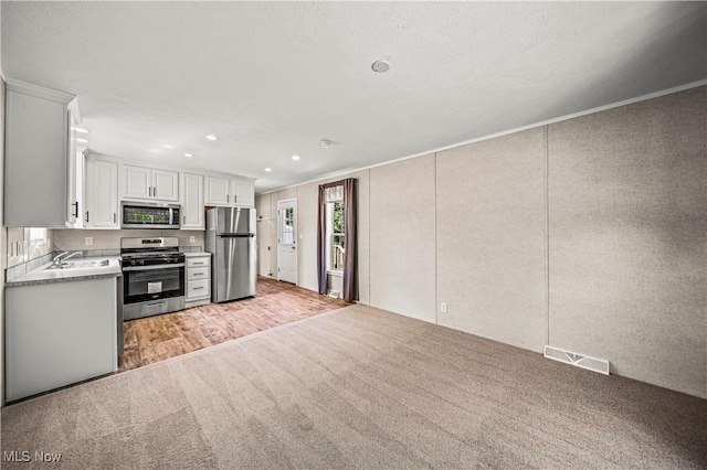 8323 Eagle Rd Unit 42, Kirtland, OH 44094 - kitchen featuring stainless steel appliances, light countertops, white cabinetry, light carpet, and recessed lighting