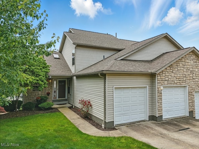 91 Falling Water Cir, Munroe Falls, OH 44262 - view of front of house with a shingled roof, an attached garage, concrete driveway, stone siding, and a front lawn