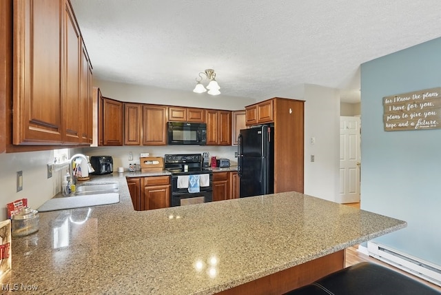 91 Falling Water Cir, Munroe Falls, OH 44262 - kitchen with black appliances, baseboard heating, a peninsula, brown cabinetry, and a textured ceiling