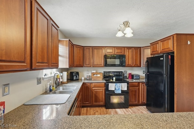 91 Falling Water Cir, Munroe Falls, OH 44262 - kitchen featuring black appliances, brown cabinets, a textured ceiling, and a chandelier