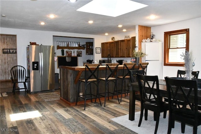 5041 W S Range Rd, Salem, OH 44460 - kitchen with stainless steel fridge, freestanding refrigerator, dark wood-style floors, a breakfast bar, and a skylight