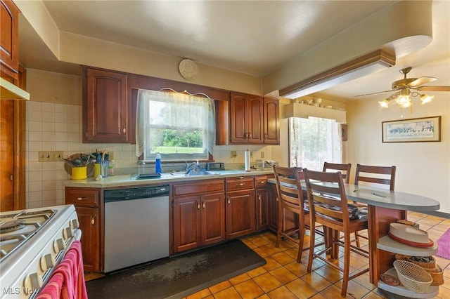 6567 Mount Everett Rd, Hubbard, OH 44425 - kitchen with dishwasher, white range with gas stovetop, light countertops, light tile patterned flooring, and tasteful backsplash